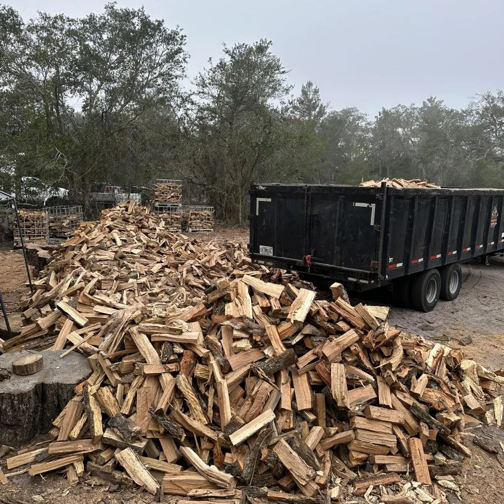 A large, rustic pile of stacked seasoned firewood logs